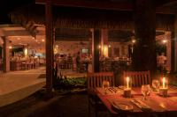 a table with candles on it in a restaurant at night at Capitán Suizo Beachfront Boutique Hotel in Tamarindo