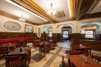 Un restaurante con mesas y sillas en una sala. en Miranda & Suizo, en San Lorenzo de El Escorial