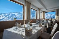 een eetkamer met witte tafels en stoelen en bergen bij Alpenhotel Laurin in Hochgurgl