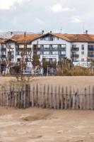 un edificio en la playa con una valla en Hôtel Serge Blanco - Relais Thalasso &amp; Spa, en Hendaya