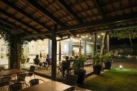 een patio met tafels en stoelen en mensen aan tafel bij Hotel Bandeirantes da Barra in Balneario Barra do Sul