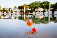 a glass of wine next to a slice of grapefruit at Hotel Rural Xereca in Puig D’en Valls