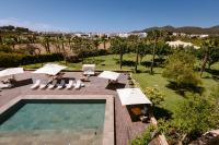 an outdoor swimming pool with umbrellas and chairs and a resort at Hotel Rural Xereca in Puig D’en Valls