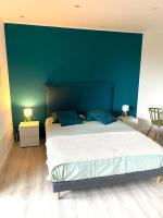 a bedroom with a large bed with a blue wall at Sélina by Les Suites d&#39;Alfred in Saint-Denis