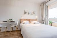 a white bedroom with a bed and a table at L&#39;Horizon in Metz