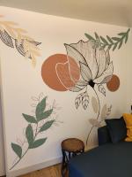 una habitación con una pared con un mural de flores. en Studio Marie, en Annonay