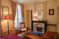 a living room with a fireplace and a table at Maison de vacances _ Le Bas Manoir in Bretteville-sur-Odon