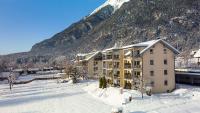 a building in the snow in front of a mountain at Apartments Schluga in Hermagor