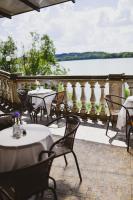un patio con mesas y sillas y vistas al lago en Hotel Solar Palace SPA & Wellness, en Mrągowo