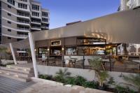 Un restaurante con mesas y sillas frente a un edificio. en O2 Beach Club & Spa All Inclusive by Ocean Hotels, en Christ Church