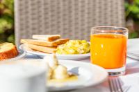 una mesa con platos de comida y un vaso de jugo de naranja en Albergo Residenziale Menhirs, en Putzu Idu