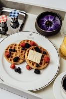 a plate of waffles with berries on it at ette luxury hotel & spa - Near Disney Theme Parks in Orlando