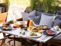 ein Tisch mit Tellern voller Speisen und Getränken in der Unterkunft Radisson Blu Zaffron Resort, Santorini in Kamari