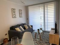 una sala de estar con un sofá y una mesa en Departamento céntrico en Puerto Varas, en Puerto Varas