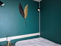a bedroom with a blue wall with a butterfly kite on the wall at Saint-Etienne Appart&#39;hôtel de Bellevue in Saint-Étienne