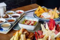 a table with several plates of food and french fries at Porto Amore Club Hotel in Alanya