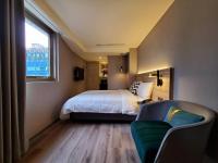 a bedroom with a bed and a couch and a window at HINOEN Hotel in Taipei