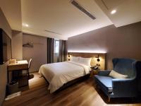 a bedroom with a bed and a blue chair at HINOEN Hotel in Taipei