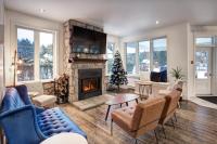 uma sala de estar com lareira e uma árvore de Natal em Le 900 Tremblant Inn Café and Bistro em Mont-Tremblant