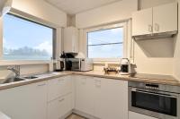 a kitchen with white cabinets and a large window at Vakantiewoning in het landelijke Staden! 10 pers - STAEDENBERGH in Staden