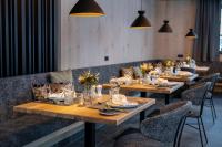 uma sala de jantar com mesas e cadeiras de madeira em Ski & Bike Hotel Wiesenegg em Saalbach Hinterglemm