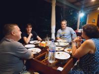 um grupo de pessoas sentadas à volta de uma mesa a comer em Palitha Homestay em Sigiriya