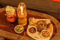 una mesa con una vela y algo de comida. en Garh Meera - A Sensational Boutique Hotel, en Jaisalmer