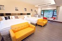 a hotel room with two beds and yellow chairs at Li Wu Zuo Cun B&amp;B in Chongde