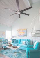 ein Wohnzimmer mit einem blauen Sofa und einem Deckenventilator in der Unterkunft Grand Beach Resort Penthouse 1 in Gulf Shores