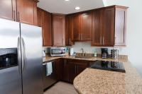 eine Küche mit Holzschränken und einem Edelstahlkühlschrank in der Unterkunft Grand Beach Resort Penthouse 1 in Gulf Shores