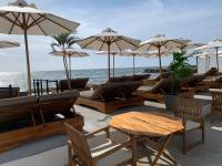 a group of tables and chairs with umbrellas on the beach at Wala Hotel and Beach Club in Cartagena de Indias