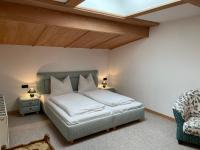 a bedroom with a bed with white sheets and a skylight at Appartement Oberlacken in Sankt Johann in Tirol