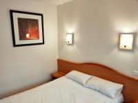 a bedroom with a bed and two lights on the wall at BRIT HOTEL Essentiel CAHORS Nord in Cahors