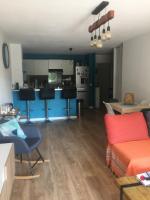 a living room with a couch and a kitchen at T3 Saint Cyr sur Mer 83270 in Saint-Cyr-sur-Mer