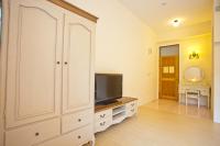 a living room with a tv and a large white cabinet at Bear Meets Moose Homestay B&amp;B in Puli