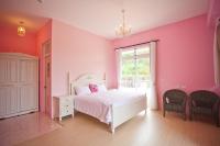 a pink bedroom with a white bed and a window at Bear Meets Moose Homestay B&amp;B in Puli