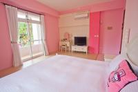 a bedroom with pink walls and a bed and a television at Bear Meets Moose Homestay B&amp;B in Puli