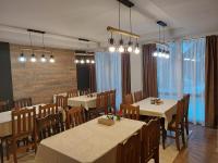 une salle à manger avec des tables, des chaises et des lumières dans l'établissement Aparthotel Pine Hills Pamporovo, à Pamporovo