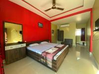 a bedroom with a bed and a red wall at APURBA GUEST HOUSE in Jorhāt