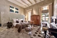 a bedroom with a bed and chairs and a piano at Casa Ellul - Small Luxury Hotels of the World in Valletta