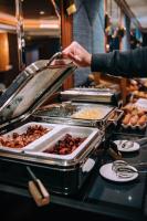 a person is serving food at a buffet at Hotel Eiffel Blomet in Paris