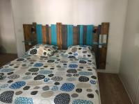 a bed with a blue and white comforter and pillows at T3 Saint Cyr sur Mer 83270 in Saint-Cyr-sur-Mer