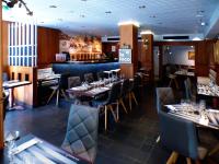 Un restaurante con mesas y sillas y un bar. en Terminus du Forez Saint-Etienne Centre Gare Chateaucreux, en Saint-Étienne