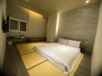 a bedroom with a white bed and a brick wall at Kiwi Express Hotel-Taichung Station II in Taichung