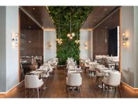 a restaurant with white chairs and tables in a room at Kaya Palazzo Resort & Casino in Kérynia