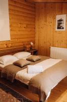 two beds in a room with wooden walls at Dolyna Mykolaya in Migovo