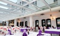 una sala da pranzo con tavoli e sedie viola e bianchi di Hotel Vila Zana a Gostivar