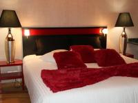 a bed with red pillows on it with two lamps at Marinha Hotel in Gentilly