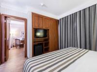 a hotel room with a bed and a flat screen tv at Hotel Cassino Tower Campinas Cambuí By Nacional Inn in Campinas