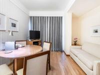 a living room with a table and a couch at Hotel Cassino Tower Campinas Cambuí By Nacional Inn in Campinas
